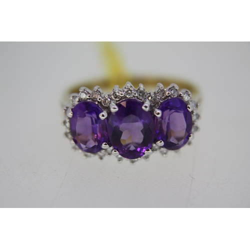 136 - Three stone amethyst and diamond ring set in gold - size O