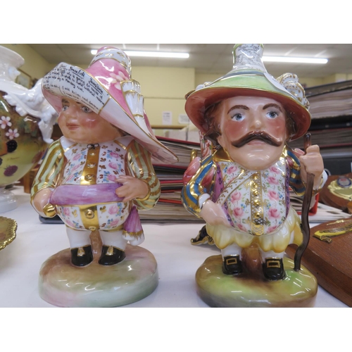 31 - Two Royal Crown Derby squat figures of men advertising events on their hats, one damaged