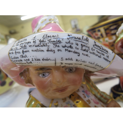 31 - Two Royal Crown Derby squat figures of men advertising events on their hats, one damaged