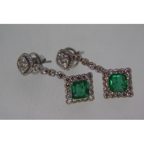 550 - 18ct white gold long drop emerald and diamond earrings, diamonds approx 2.4cts, emeralds approx 3cts