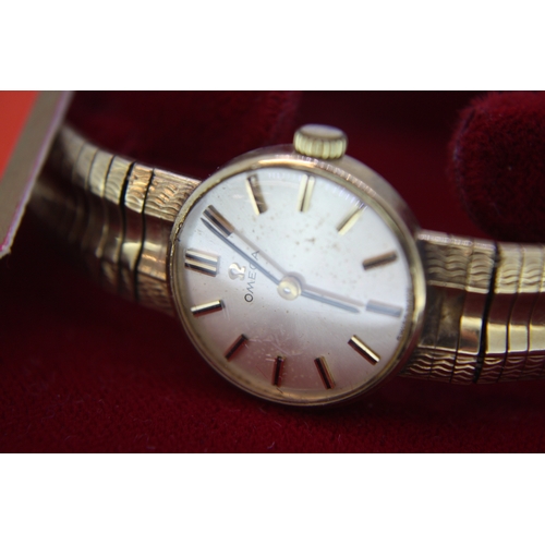 299 - Ladies' 9 ct. gold OMEGA wind up wrist watch with integral gold strap  (boxed with manual) c1965