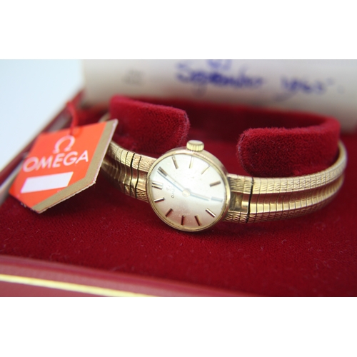 299 - Ladies' 9 ct. gold OMEGA wind up wrist watch with integral gold strap  (boxed with manual) c1965