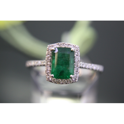 301 - Platinum ring set with step cut emerald surrounded by diamonds (emerald 1.35 cts) - size P