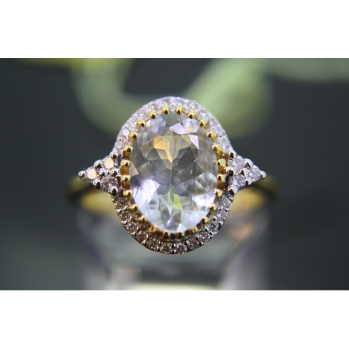 302 - 14 ct. gold oval aquamarine and diamond cluster ring with diamond shoulders - size P