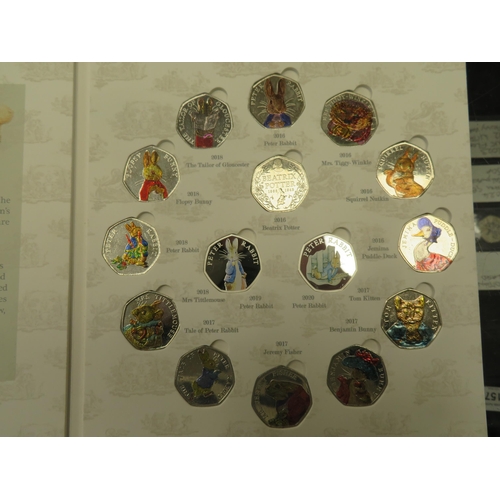 97 - Beatrix Potter 50p coin album, containing coloured 50 pence pieces and two silver Peter Rabbit coins