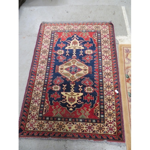 390 - Two rugs, one in mainly blue and red wools with geometric designs, one floral