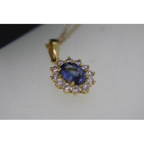 313 - 18 ct. white gold oval sapphire and diamond cluster pendant on an 18 ct. gold chain