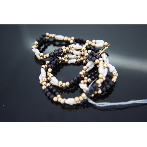 61 - 9 ct gold misshapen pearl black bead necklace