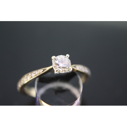 304 - A 9 ct gold solitaire diamond ring with diamond shoulders with certificate