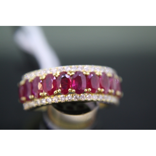 292 - 18 ct. gold ring set with eleven oval rubies and having a diamond border - size O