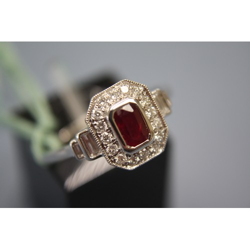 325 - Platinum ring with Art Deco style step cut ruby surrounded by diamonds, size P