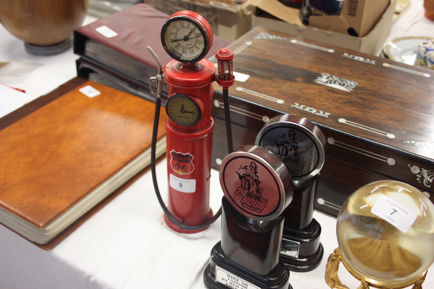 Two bike trophies together with a clock in the form of a petrol pump