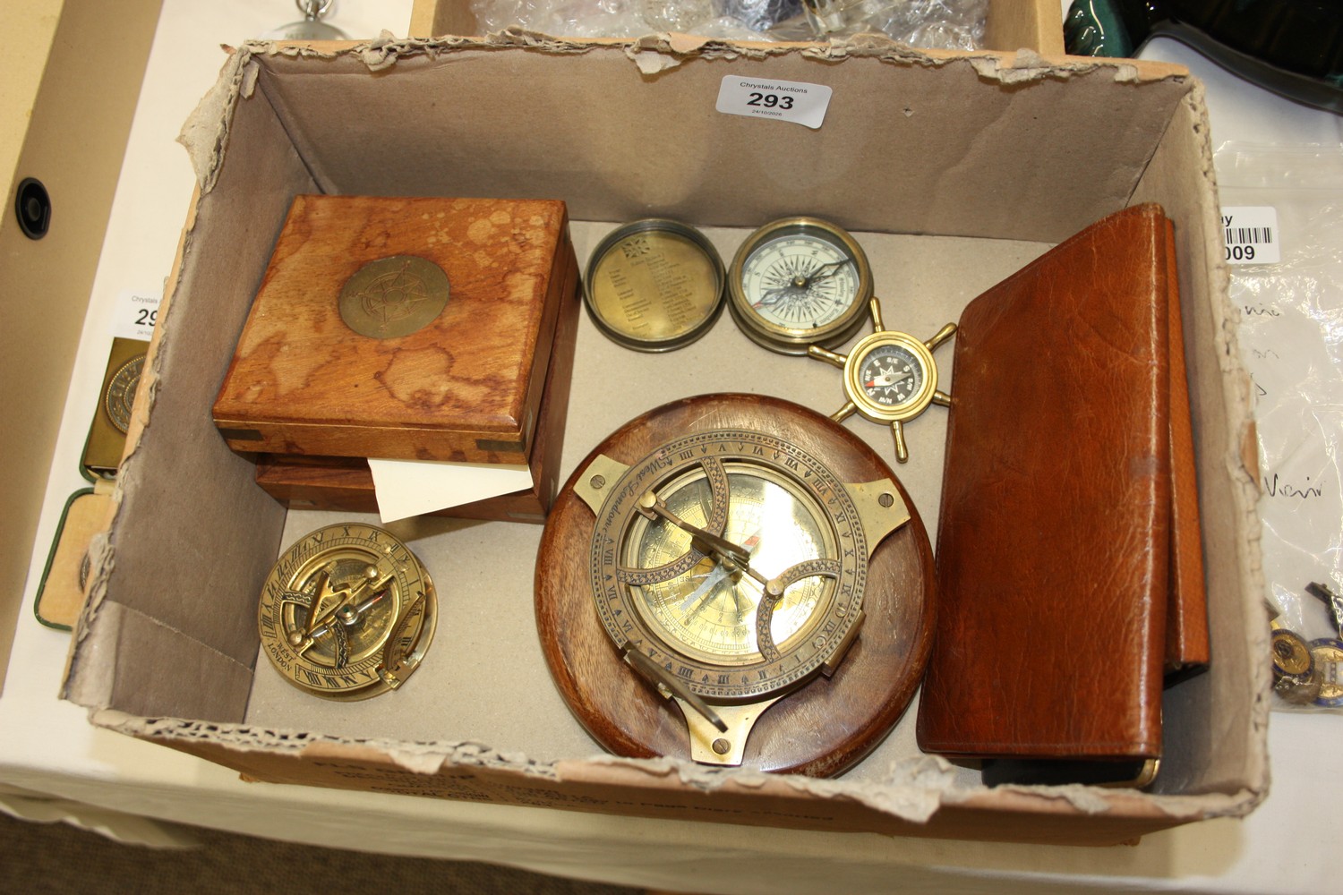 A collection of brass compasses, sundials together with wallets
