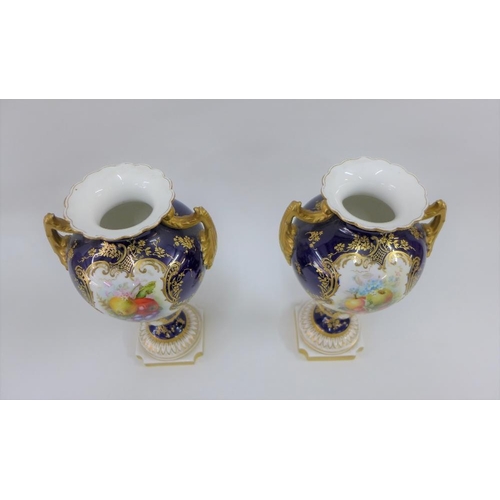 109 - A pair of Royal Worcester vases with gilt twin handles and hand painted fruit panels, signed Hawkins... 