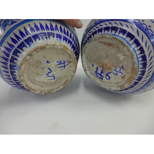 81 - A pair of Middle Eastern style bottle neck vases, painted with flowers and figures to a turquoise gr... 