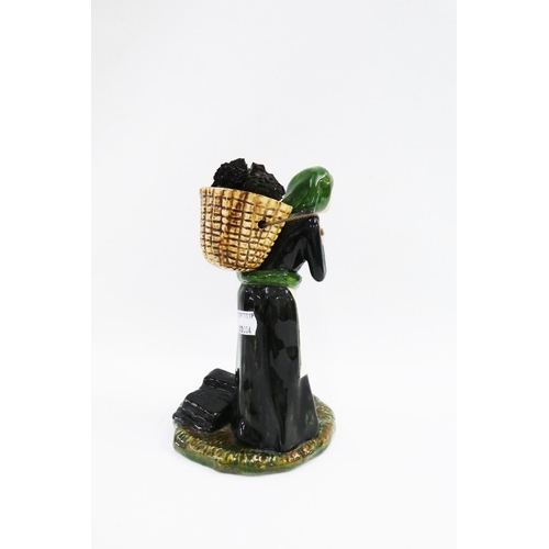 115 - Coll Pottery female figure, modelled standing with a peat basket on her bag, 22cm high