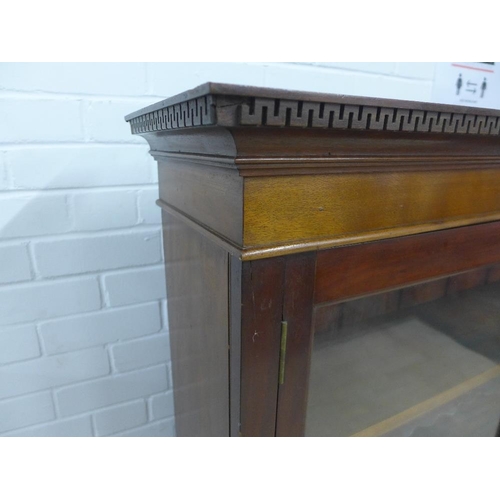 228 - Mahogany bookcase with dentil frieze and pair of glazed doors, with a shelved interior, 155 x 123cm