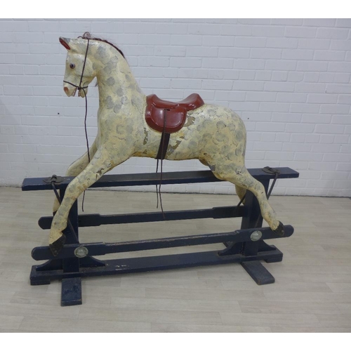 212 - Dapple rocking horse on a black wooden trestle base, 112 x 132cm