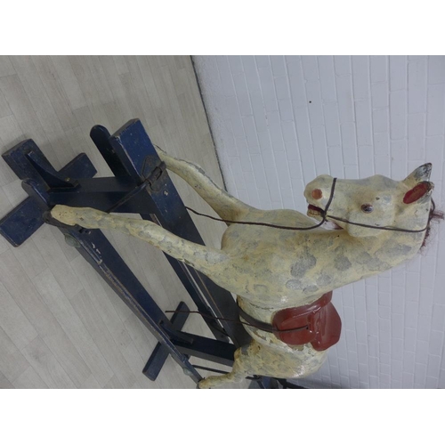 212 - Dapple rocking horse on a black wooden trestle base, 112 x 132cm