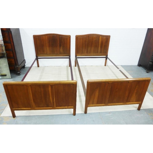 230 - Pair of Gordon Russell three fielded panel walnut beds, on chamfered supports, complete with side ra... 