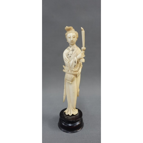 354 - Early 20th century ivory okimono of a woman, modelled standing with a candle, on a wooden plinth bas... 