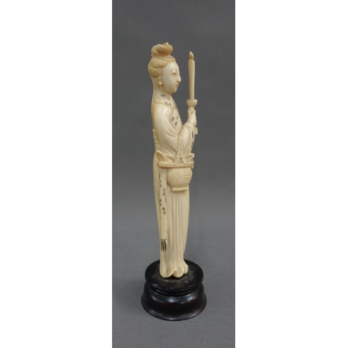 354 - Early 20th century ivory okimono of a woman, modelled standing with a candle, on a wooden plinth bas... 