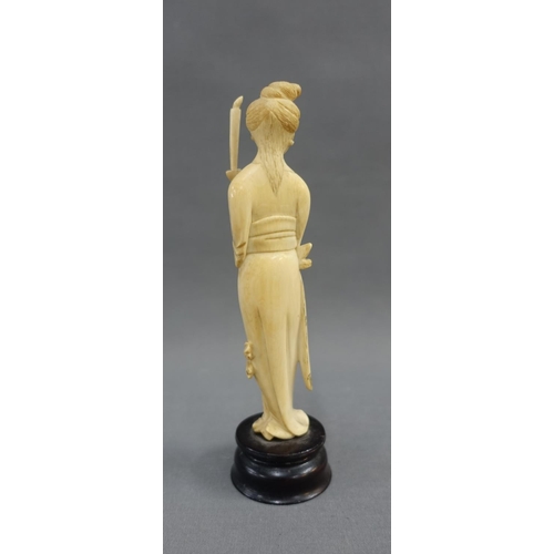 354 - Early 20th century ivory okimono of a woman, modelled standing with a candle, on a wooden plinth bas... 