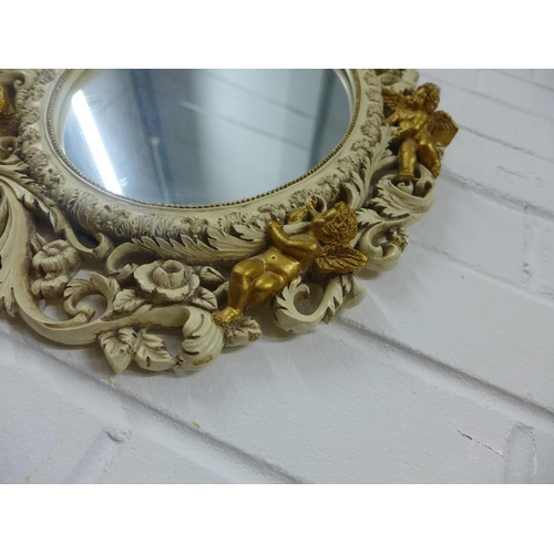 447 - Oval wall mirror with pierced foliate frame with faux giltwood cherubs, 40 x 33cm