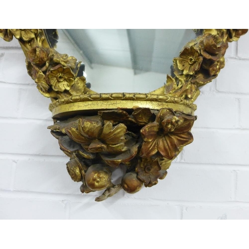 456 - Floral giltwood mirror with pier shelf, the oval plate surmounted with a ribbon swag within a surrou... 