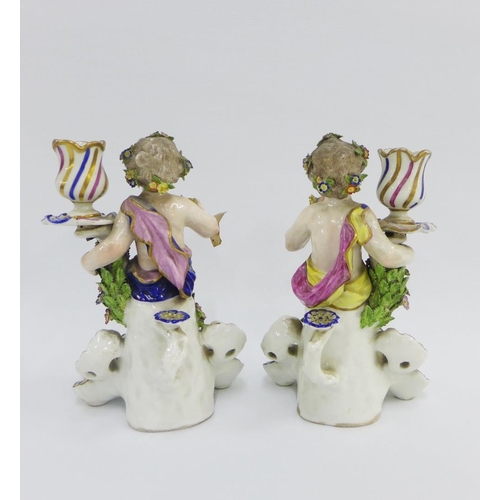 78 - Pair of porcelain cherub figural candlesticks, modelled in the manner of Bow,  on rococo shell bases... 