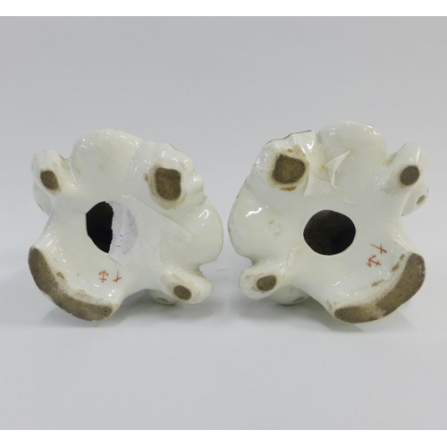 78 - Pair of porcelain cherub figural candlesticks, modelled in the manner of Bow,  on rococo shell bases... 