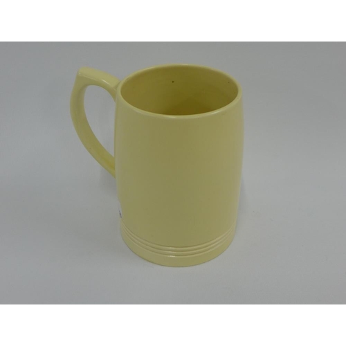 95 - Keith Murray for Wedgwood, a straw coloured pottery tankard, printed factory backstamps, 12cm high