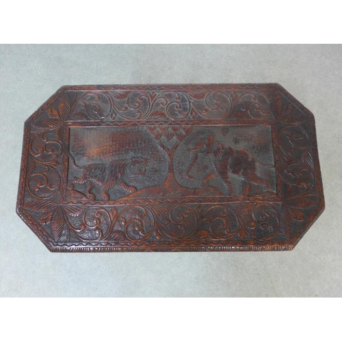 212 - An early 20th century two tier table, the rectangular top with carved elephant and tiger pattern, on... 