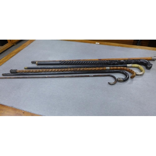 414 - A collection of six late 19th and early 20th century walking canes to include silver mounted, ebonis... 