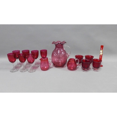 127 - Collection of cranberry glass to include a water jug, various drinking glasses, two small jugs and a... 