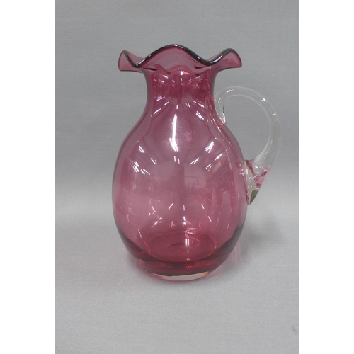 127 - Collection of cranberry glass to include a water jug, various drinking glasses, two small jugs and a... 