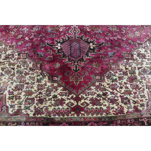 201 - North West Persian Heriz carpet, red field with central medallion, angular foliage and flowerhead bo... 