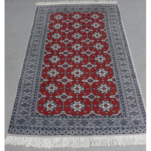 226 - Pakistan rug, red field with allover foliate pattern, within geometric borders, 182 x 122cm