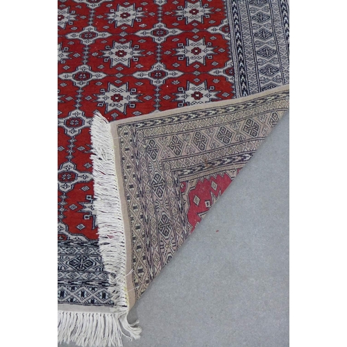 226 - Pakistan rug, red field with allover foliate pattern, within geometric borders, 182 x 122cm