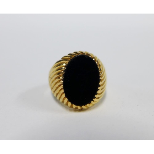 77 - 18ct gold ring with an oval black hardstone plaque, stamped 750 UK ring size O