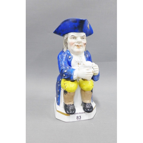 83 - 19th century Toby Jug, typically modelled seated with a jug of ale, wearing blue frock coat and tric... 