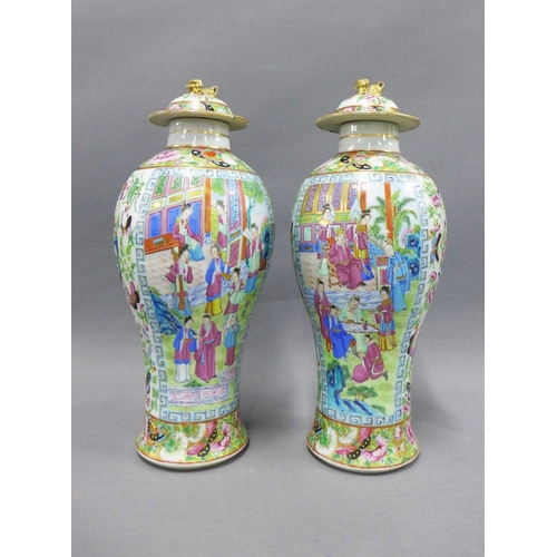 84 - A pair of Chinese famille rose 'Mandarin' lidded baluster vases, typically painted with figures, flo... 