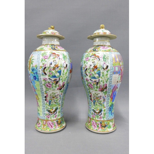 84 - A pair of Chinese famille rose 'Mandarin' lidded baluster vases, typically painted with figures, flo... 