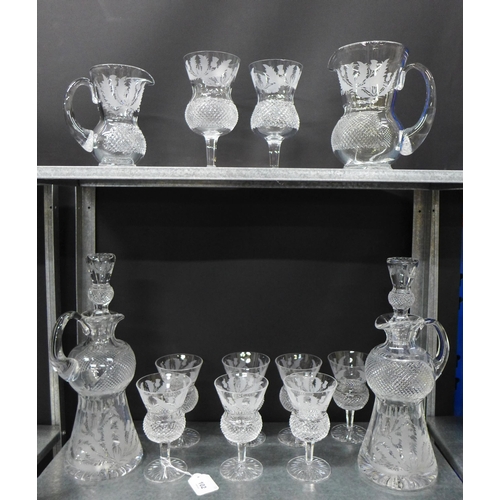 102 - Collection of thistle etched crystal to include a pair of decanters with stoppers, set of seven wine... 