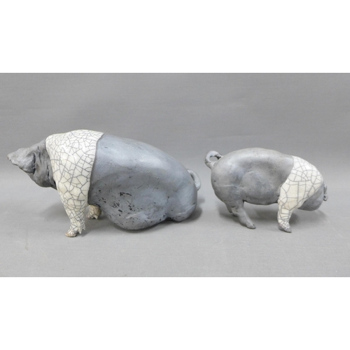 117 - Raku glazed Saddleback Sow, modelled sitting, 23cm long, together with a smaller pig, signed indisti... 