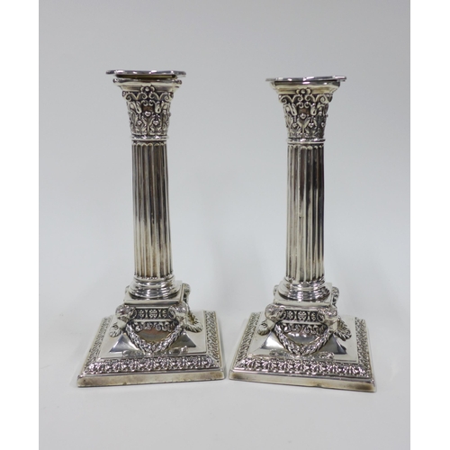 74 - A pair of Edwardian Adam style silver plated desk candlesticks, on square bases with rams head detai... 