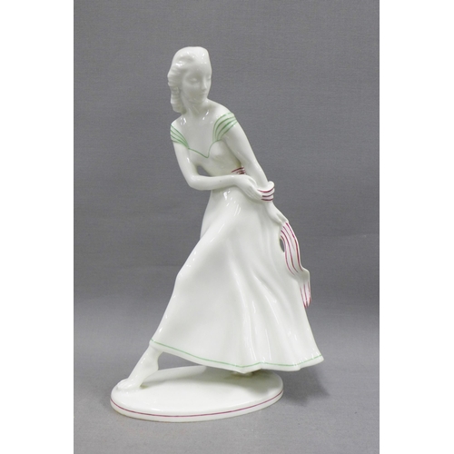 92 - Art Deco porcelain female figure, modelled walking wearing a dress with green and red striped detail... 