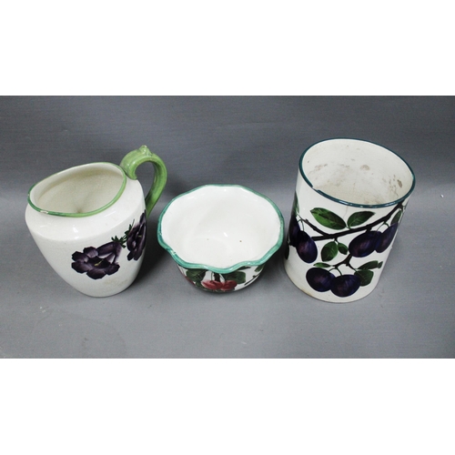 147 - Wemyss ware pottery to include a jug with pansies pattern, bowl with plums and a tankard (handle lac... 