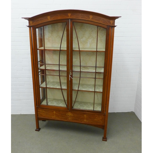 201 - Art Nouveau mahogany inlaid cabinet with an arched top over a pair of glazed doors, with fabric line... 