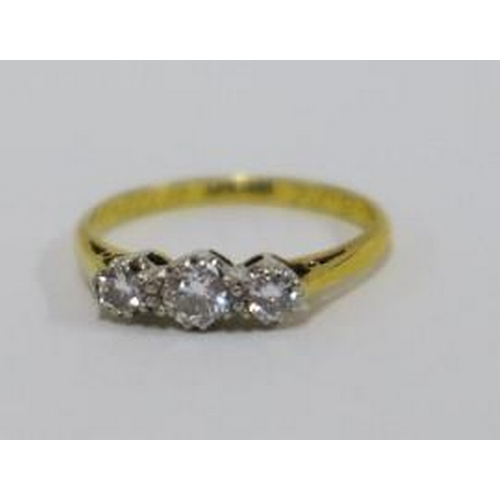 63 - Three stone diamond ring, claw set in platinum on an 18ct gold band, size O